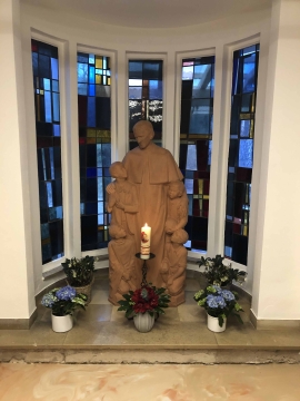 Die Statue zeigt Don Bosco inmitten von Kindern. 